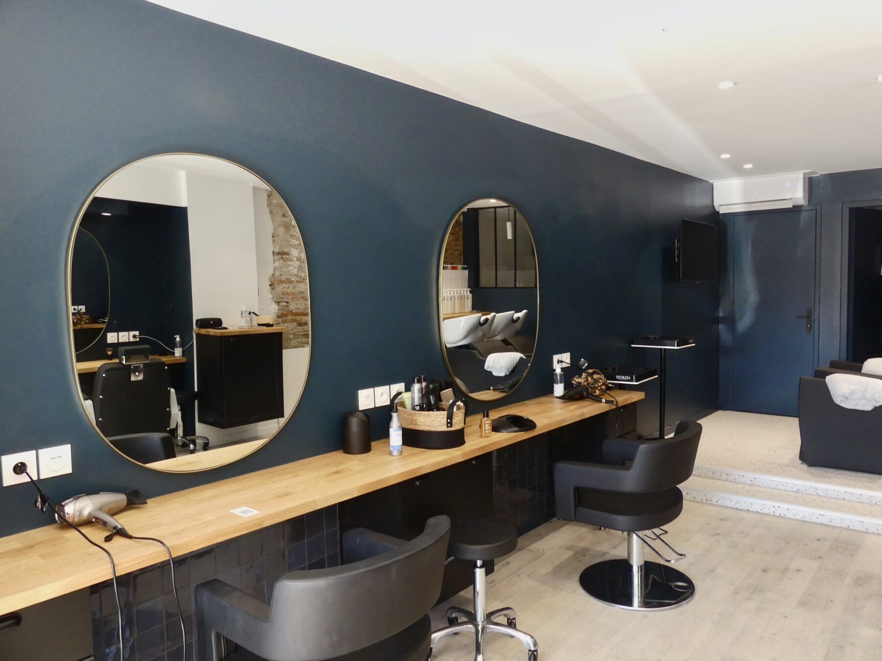 Postes de coiffure avec miroirs ronds et plan de travail en bois à St Cyprien