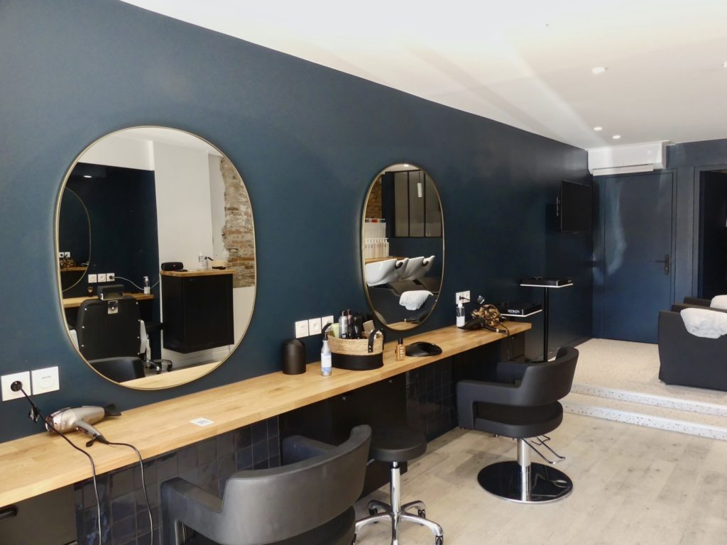Postes de coiffure avec miroirs ronds et plan de travail en bois à St Cyprien