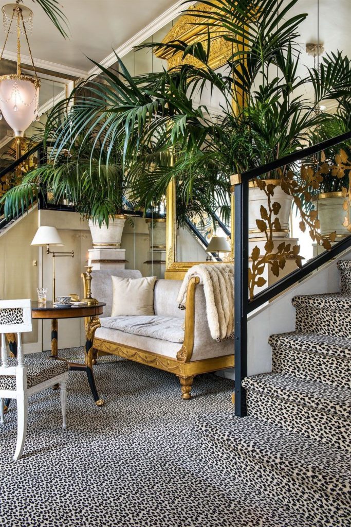 Intérieur de style Madeleine Castaing avec mobilier classique et végétation luxuriante